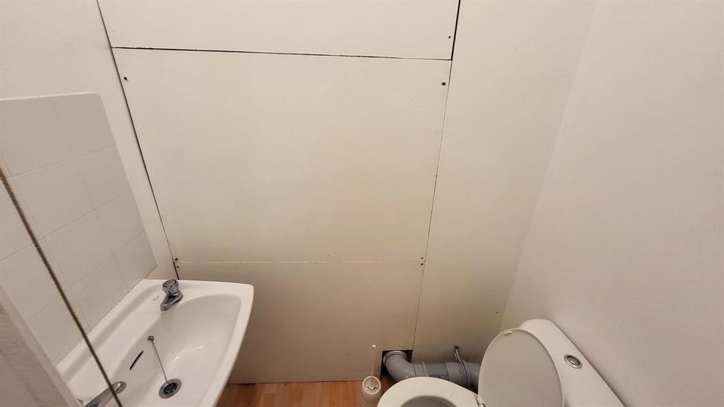 Compact and clean single toilet featuring a whi...