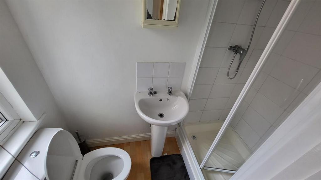 A clean, compact bathroom featuring a white toi...