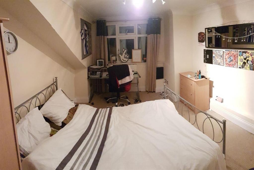 A cozy and well-kept master bedroom featuring a...