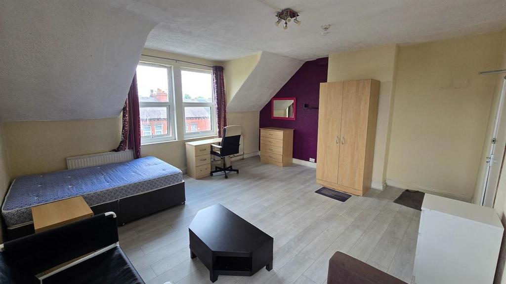 A spacious master bedroom featuring a large win...