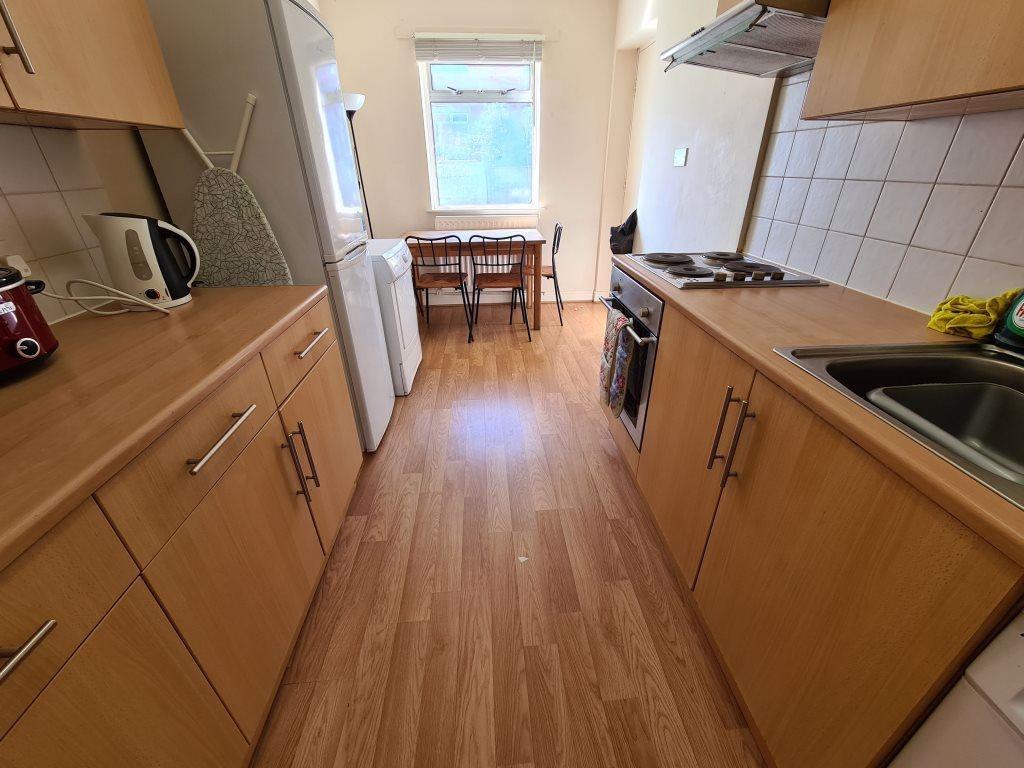 Bright and tidy kitchen with wooden cabinetry a...