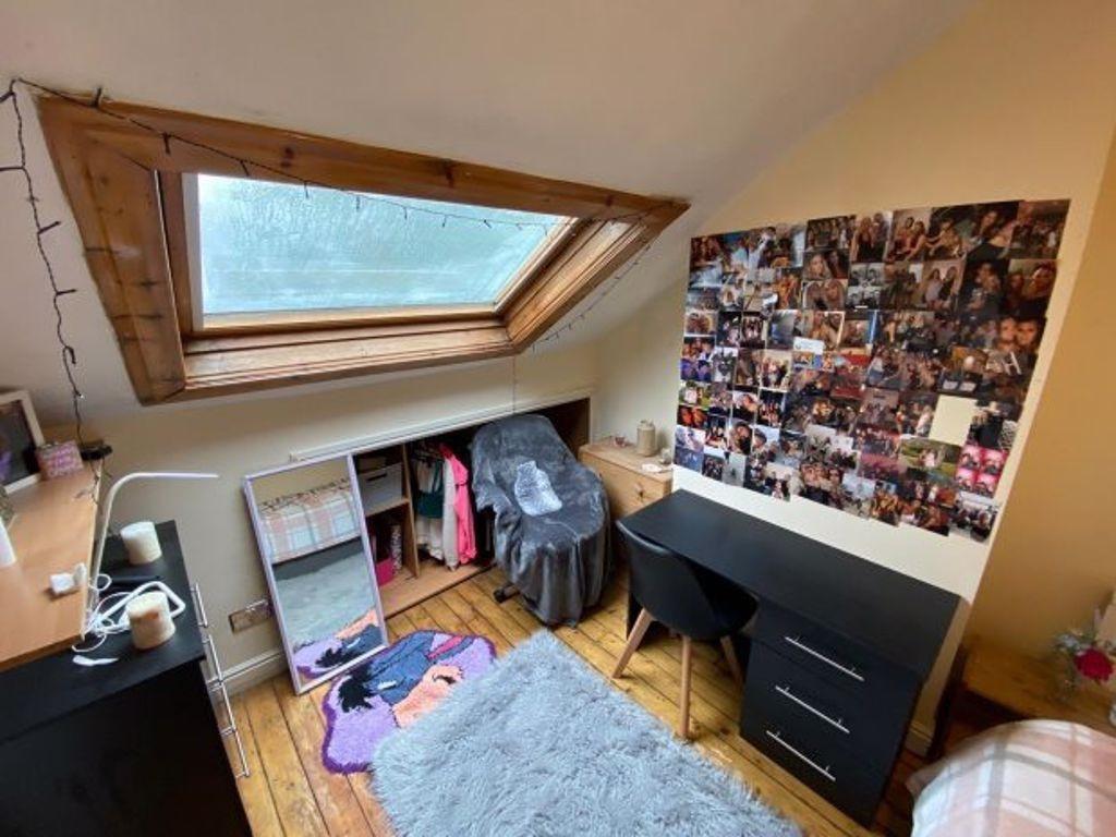 Cozy single bedroom featuring a sloped skylight...