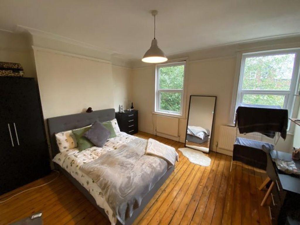 A cozy double bedroom featuring warm wooden flo...