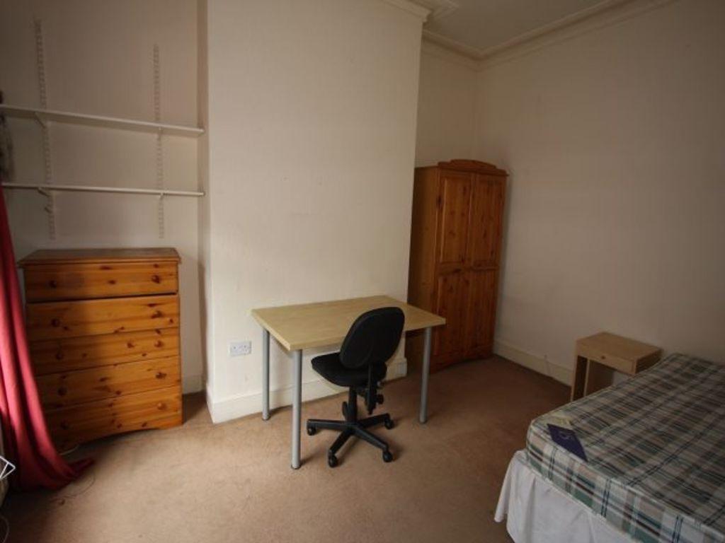 A cozy single bedroom featuring a bed, a wardro...