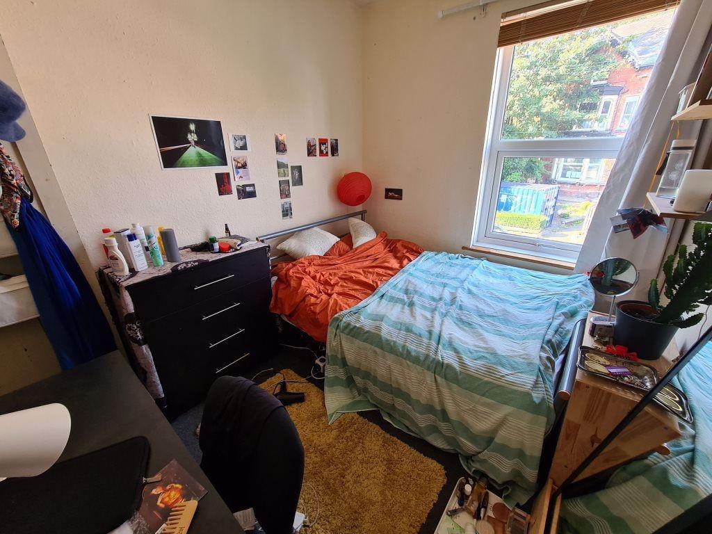A bright and cozy bedroom featuring an orange b...