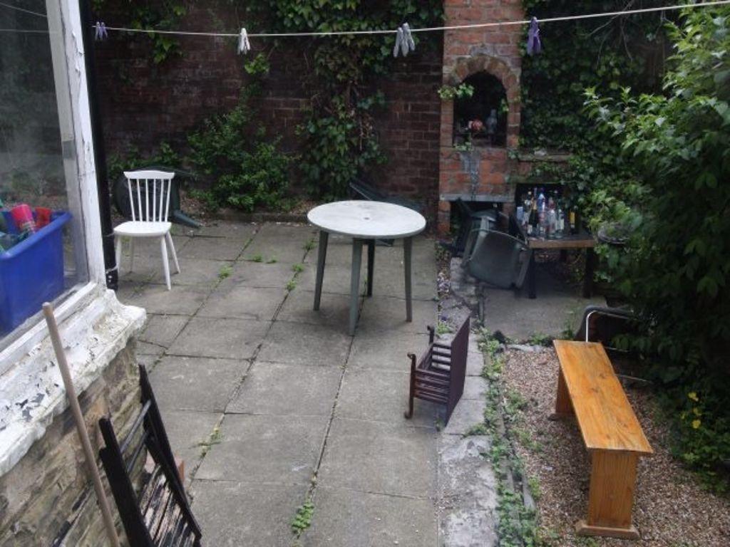 A tidy outdoor garden area with paving, a few c...