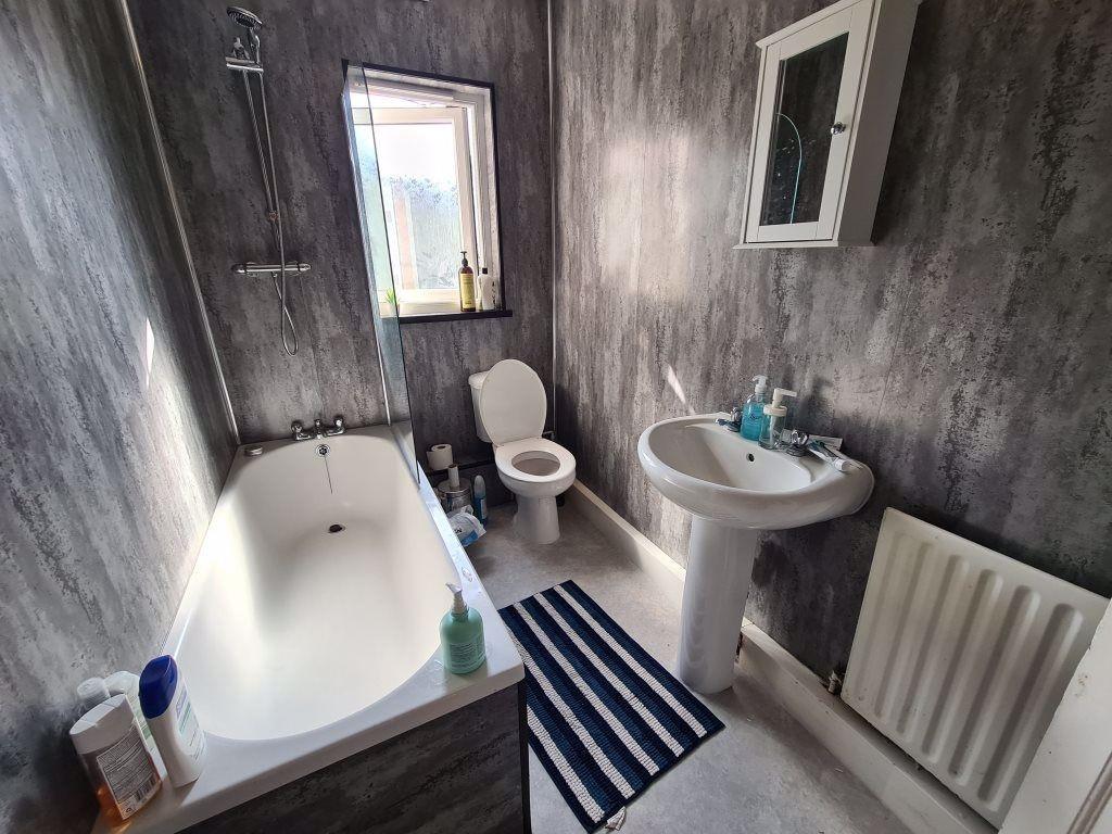 A well-maintained bathroom featuring a bathtub,...