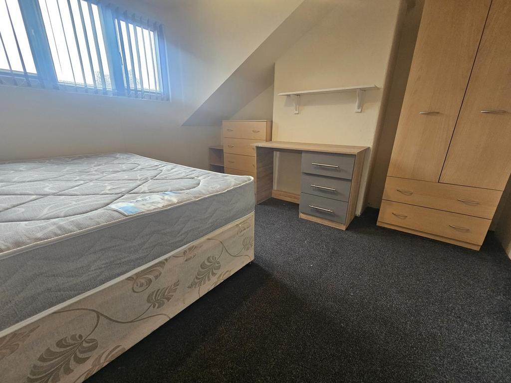 A neatly organized student bedroom featuring a ...