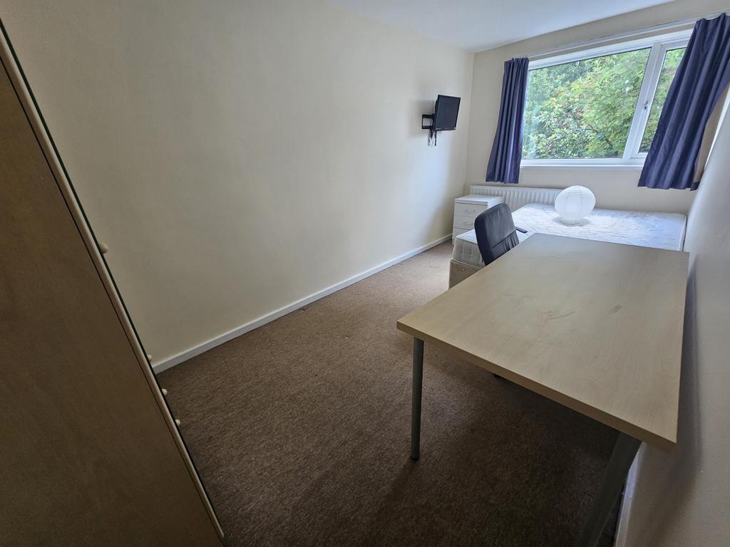 A well-lit, clean room featuring a large window...