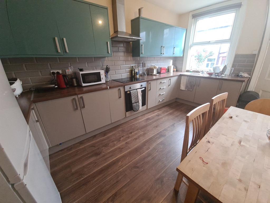 A bright and modern kitchen featuring wood-effe...
