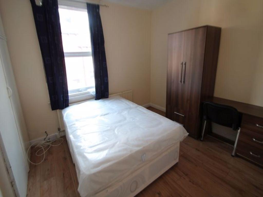 A tidy bedroom with a comfortable double bed, a...
