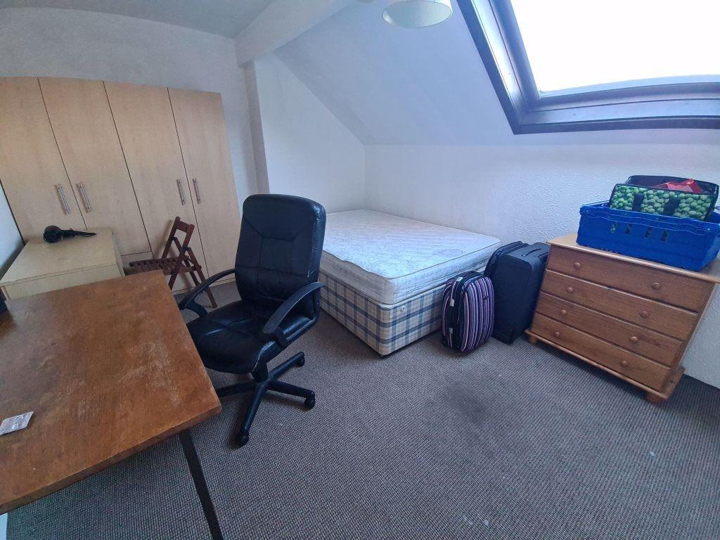 A cozy single bedroom with a large skylight win...