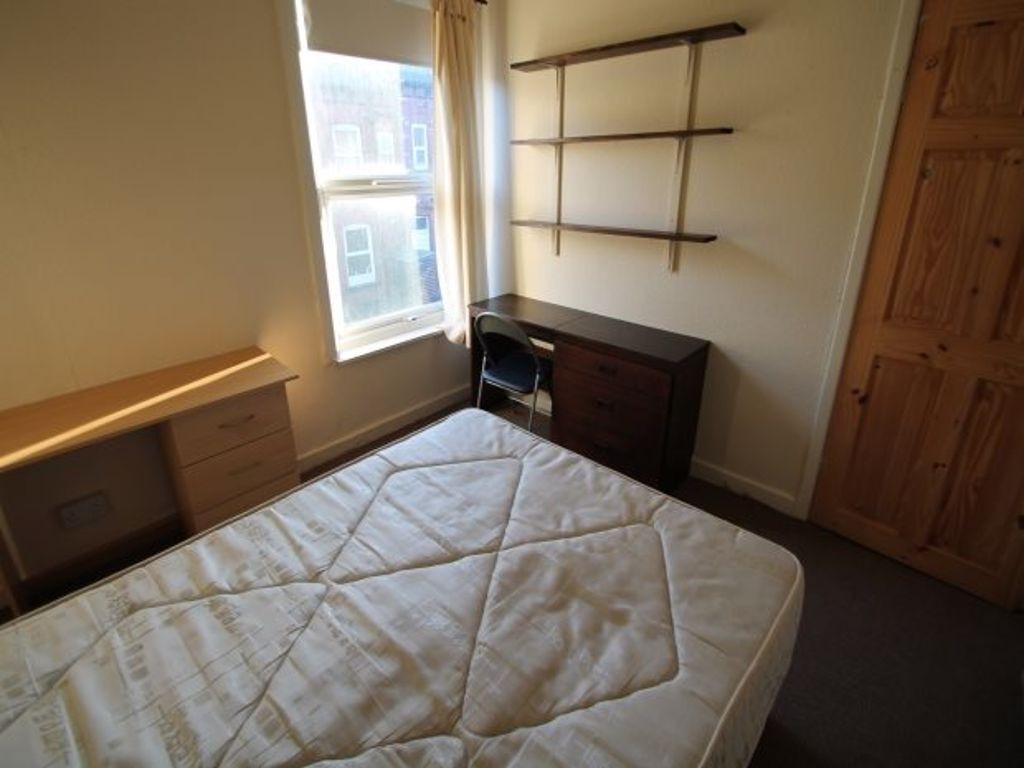 Cozy single bedroom featuring a large window th...