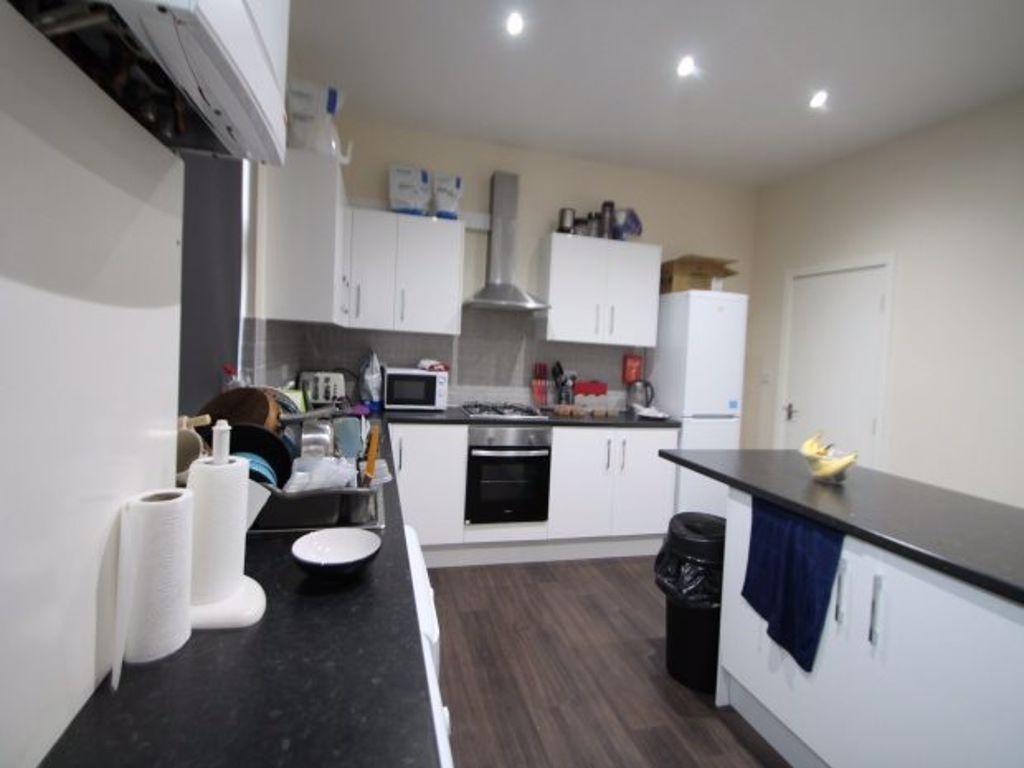 A modern kitchen featuring sleek white cabinets...