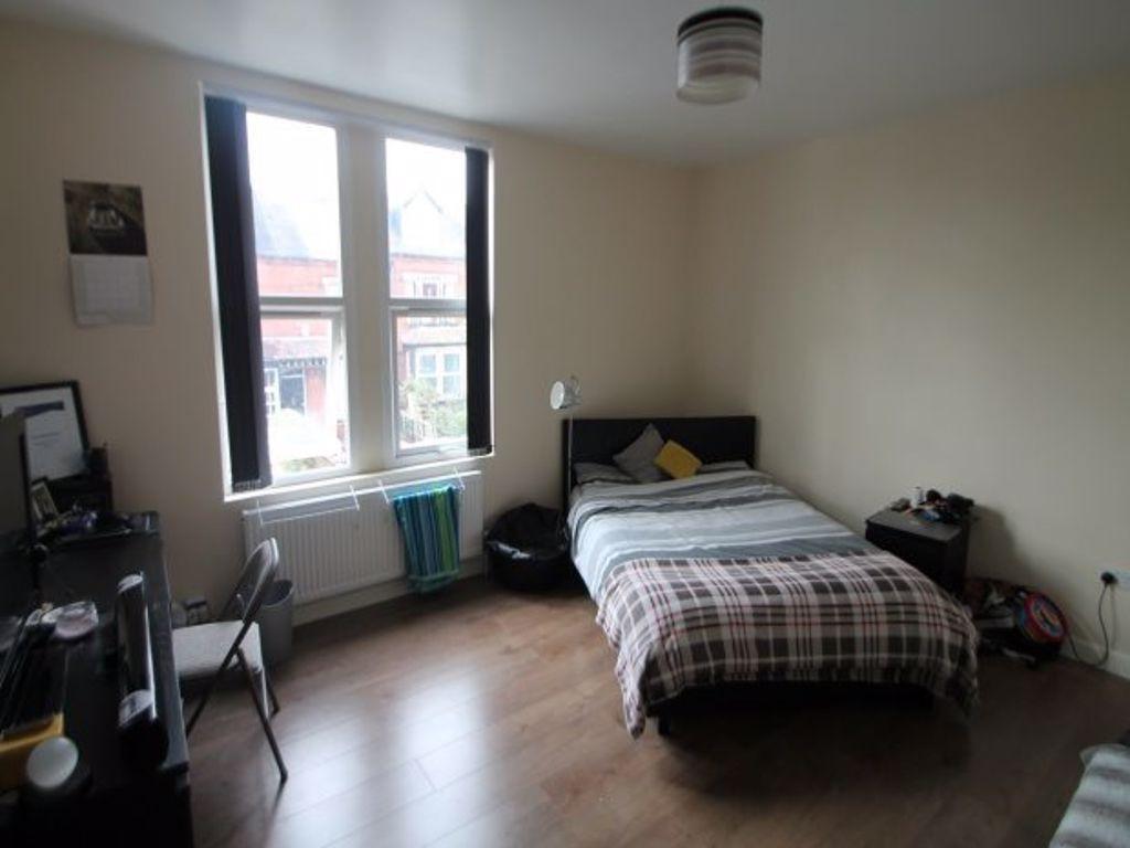 A bright double bedroom featuring a large windo...