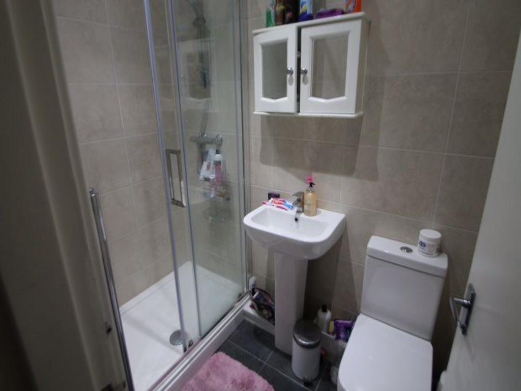A modern bathroom suite featuring a glass-enclo...
