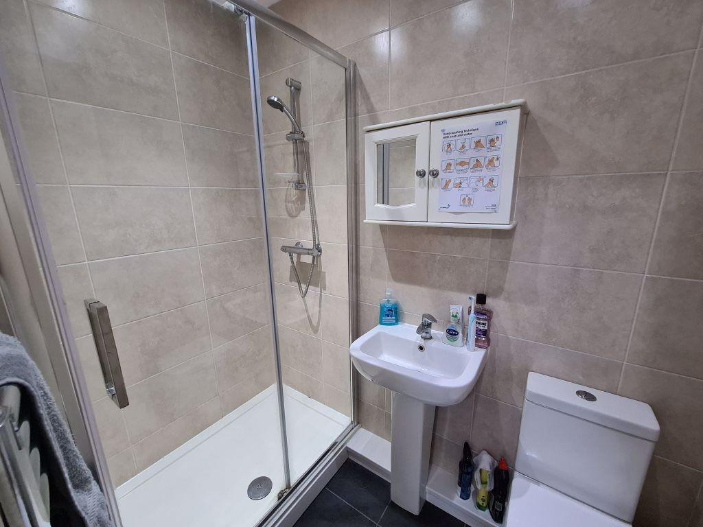 Modern bathroom featuring a glass-enclosed show...