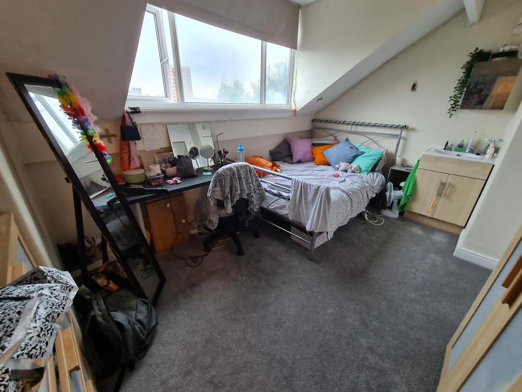 Bright attic-style bedroom with a large angled ...
