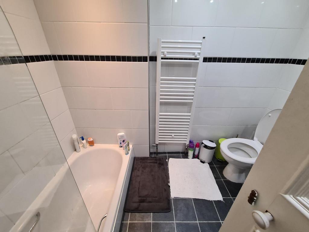 Neat, modern bathroom with a bathtub, heated to...