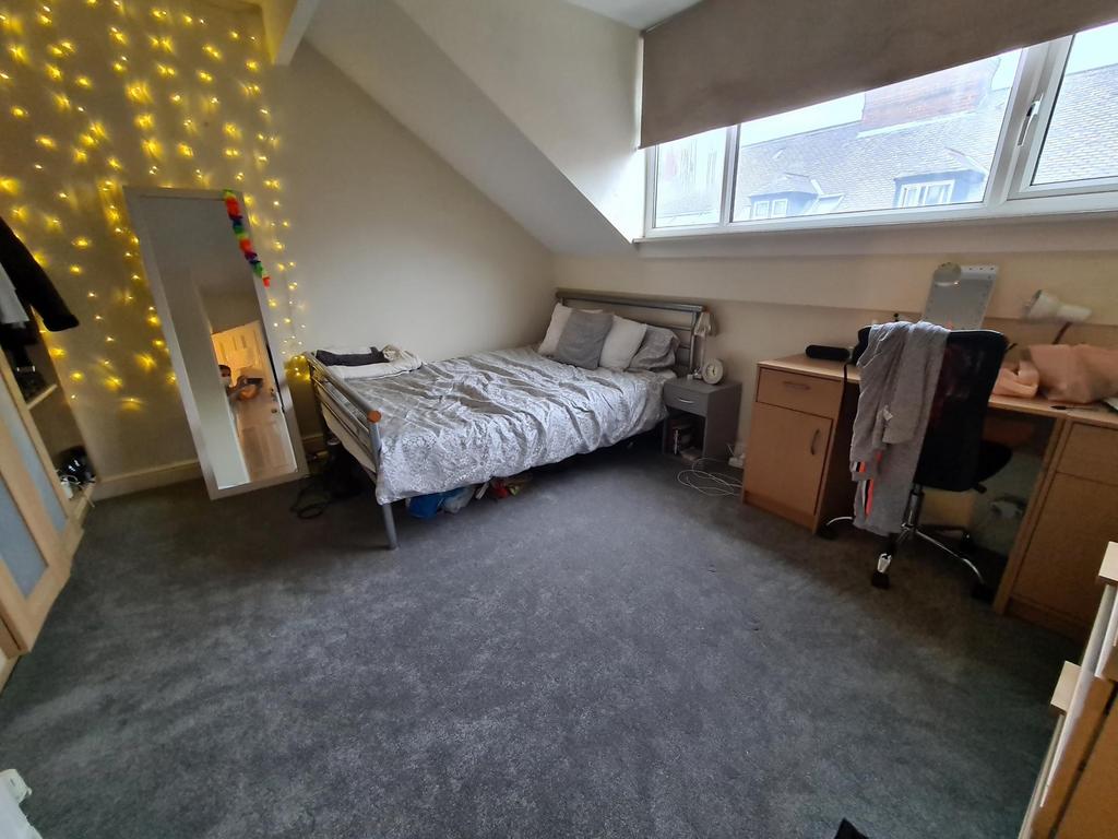 Bright, neatly arranged bedroom with a comforta...