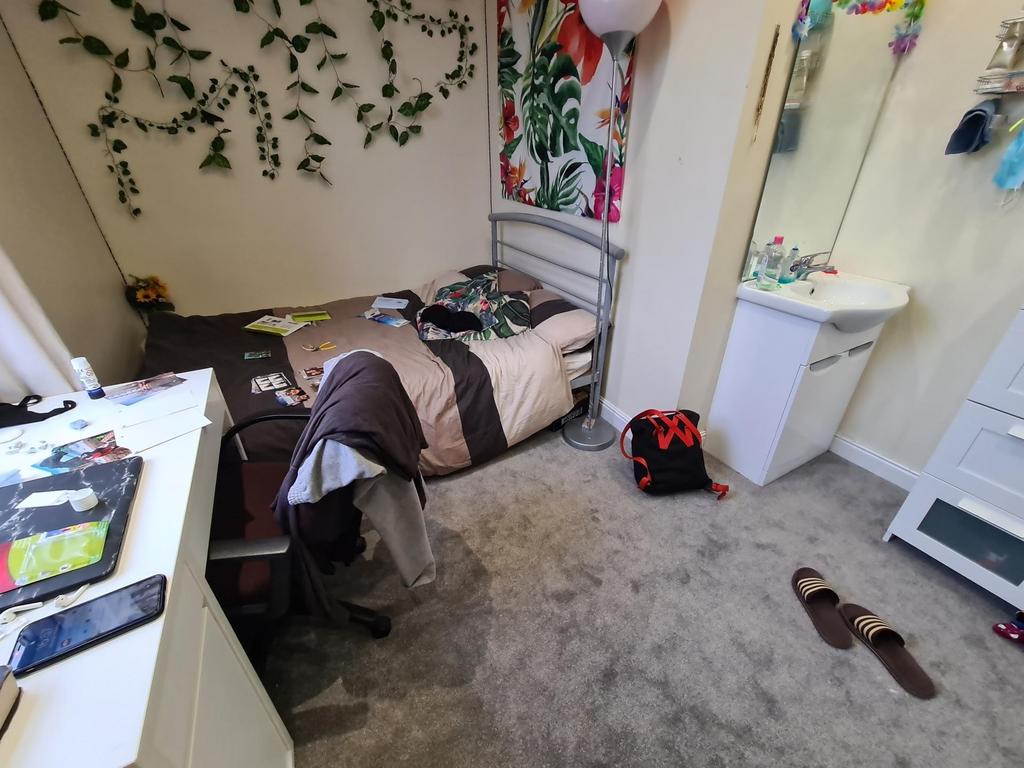 Cozy single bedroom with soft carpeting, decora...