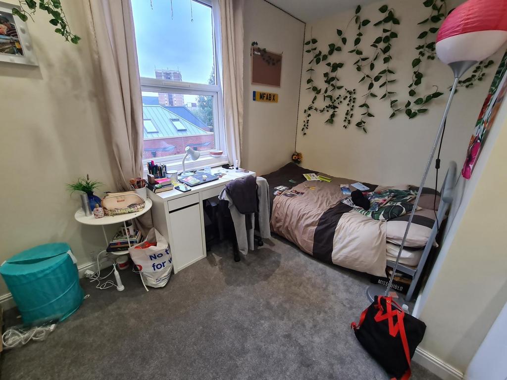 Cozy single bedroom featuring a neatly made bed...