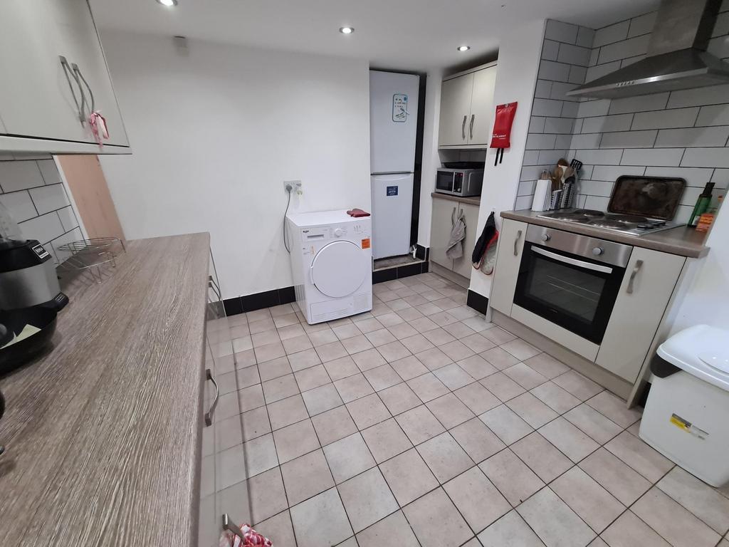 Bright, modern kitchen with tiled flooring, int...