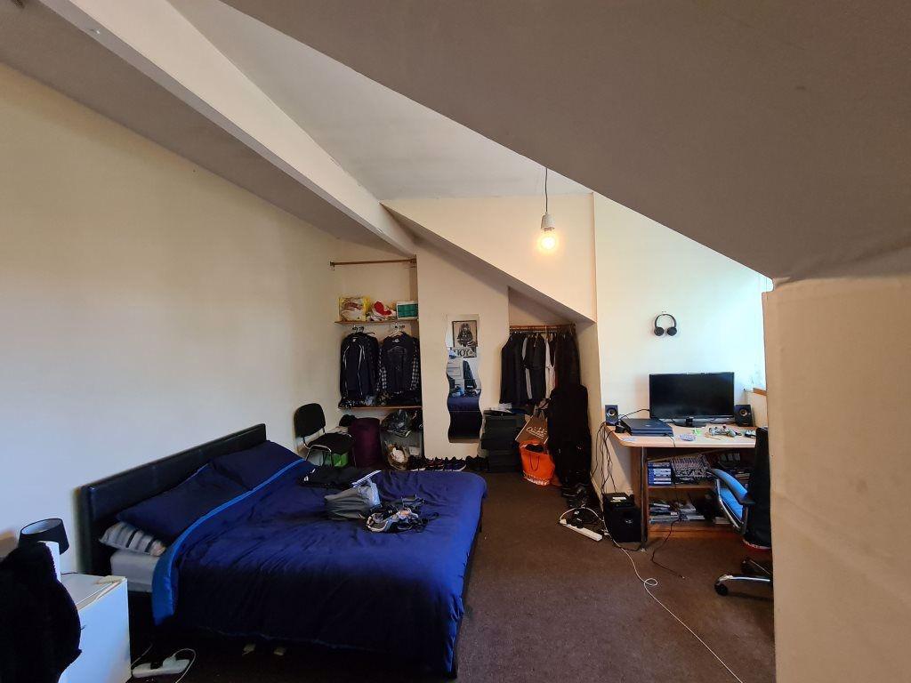 A spacious master bedroom featuring a comfortab...