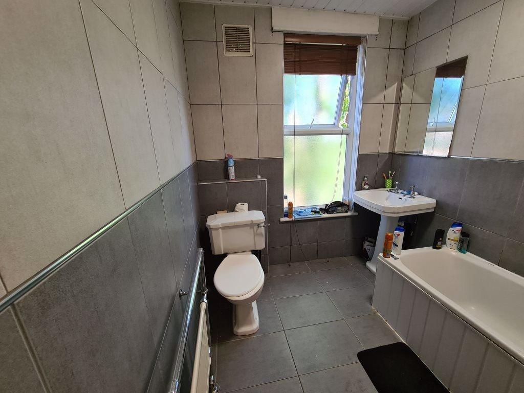 A modern bathroom featuring a white bathtub, pe...