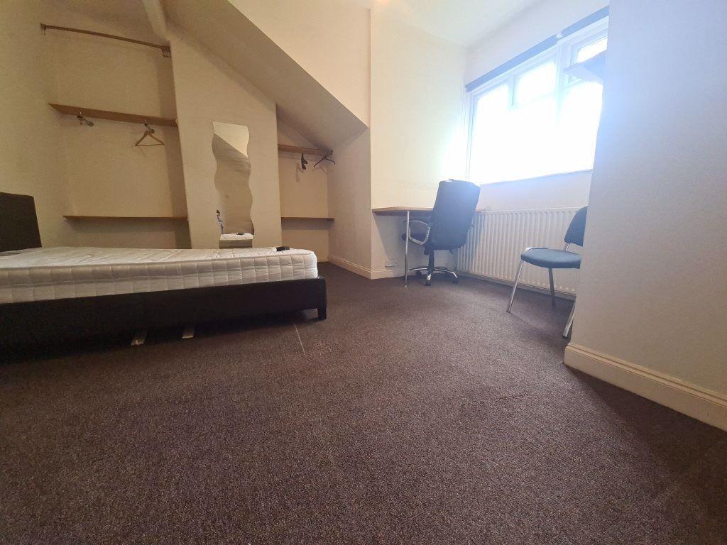 A simple single bedroom featuring a neatly made...