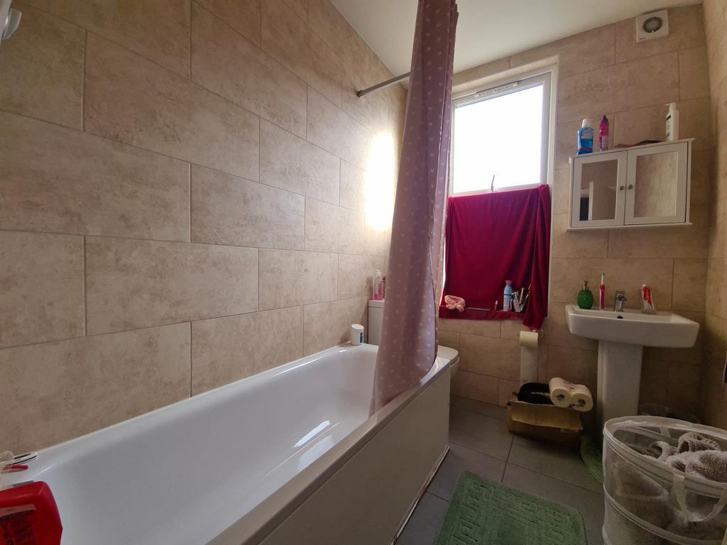 A bright bathroom suite featuring a full bathtu...