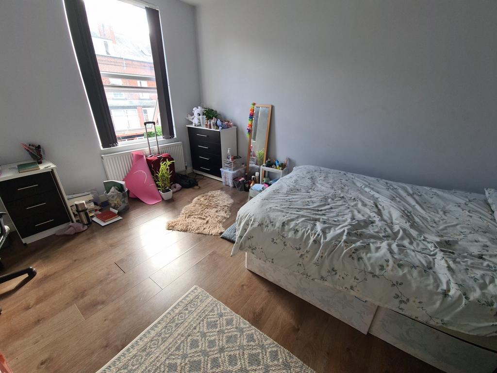 A cozy and bright bedroom with a single bed, wo...