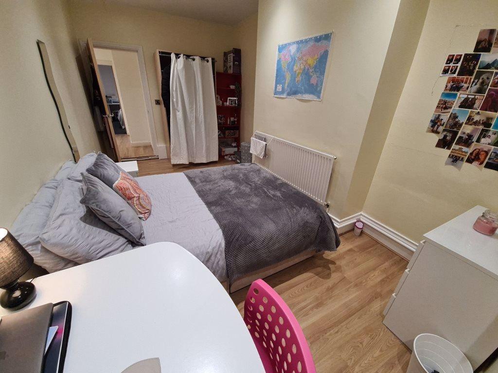 A bright and tidy bedroom with a comfortable do...