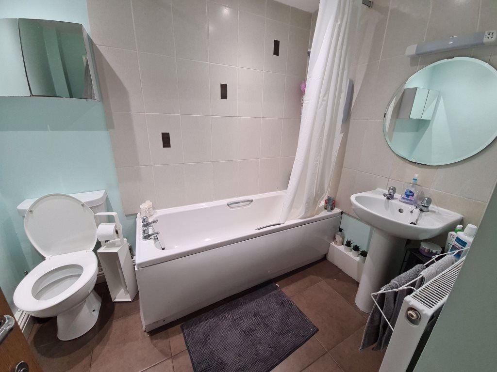 A well-maintained bathroom featuring a bathtub ...