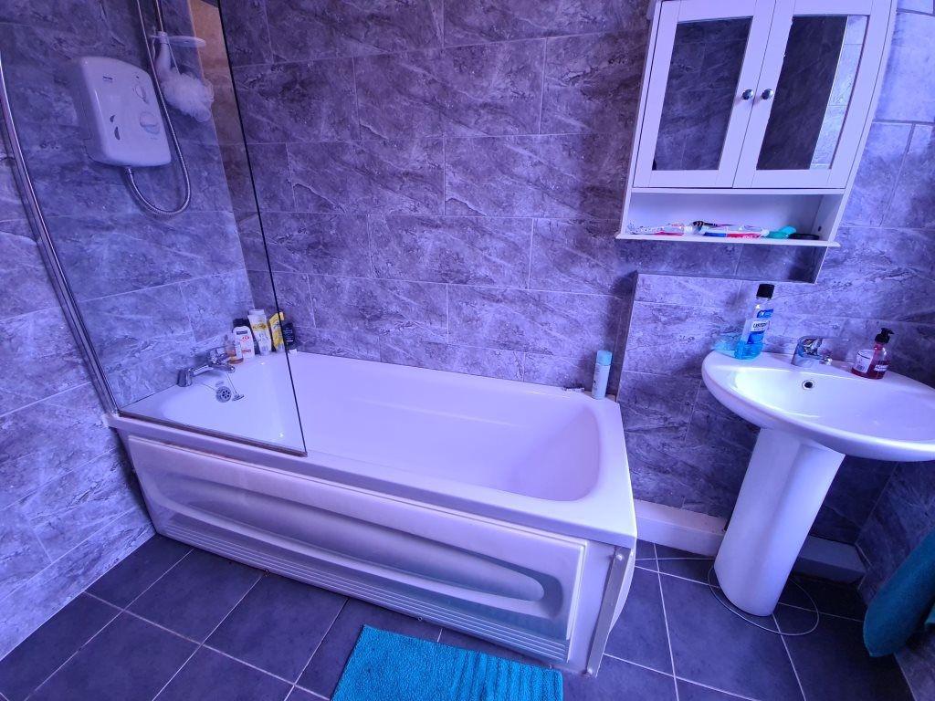 A modern bathroom featuring a clean white batht...