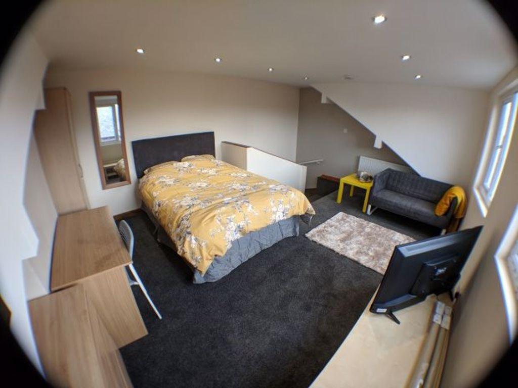 A spacious, well-lit master bedroom featuring a...