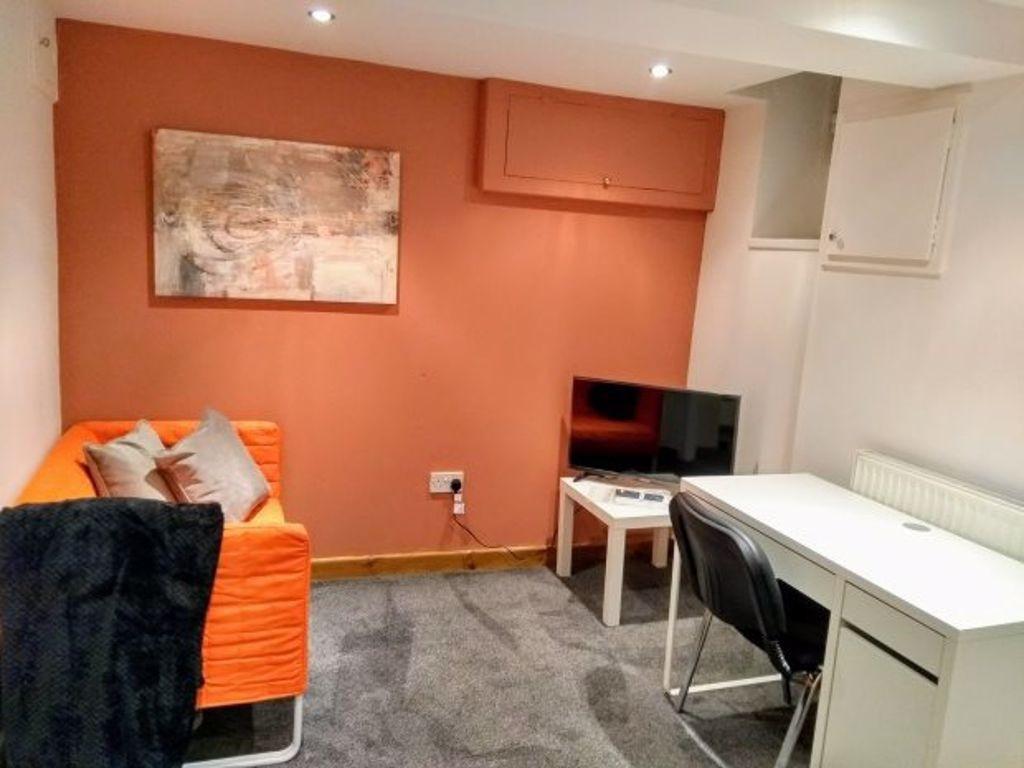 A cozy communal lounge featuring a bright orang...