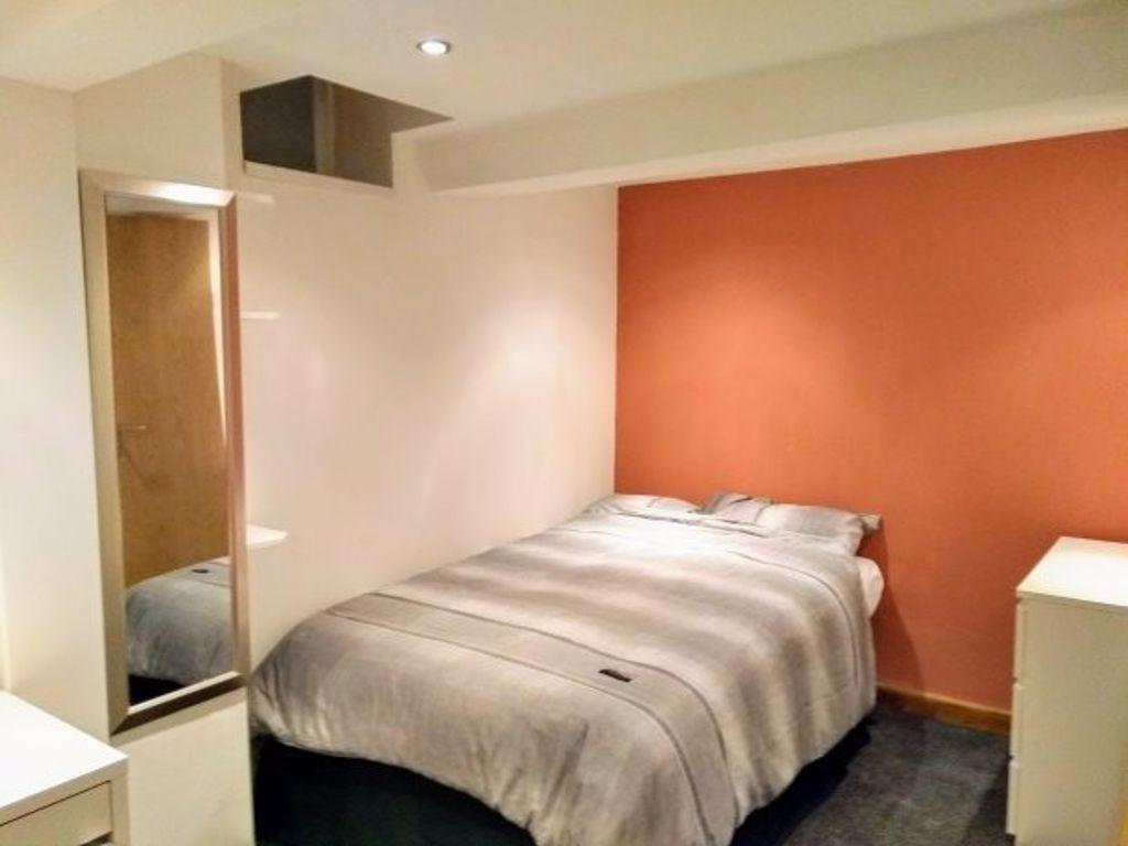 Cozy single bedroom featuring a soft, warm colo...