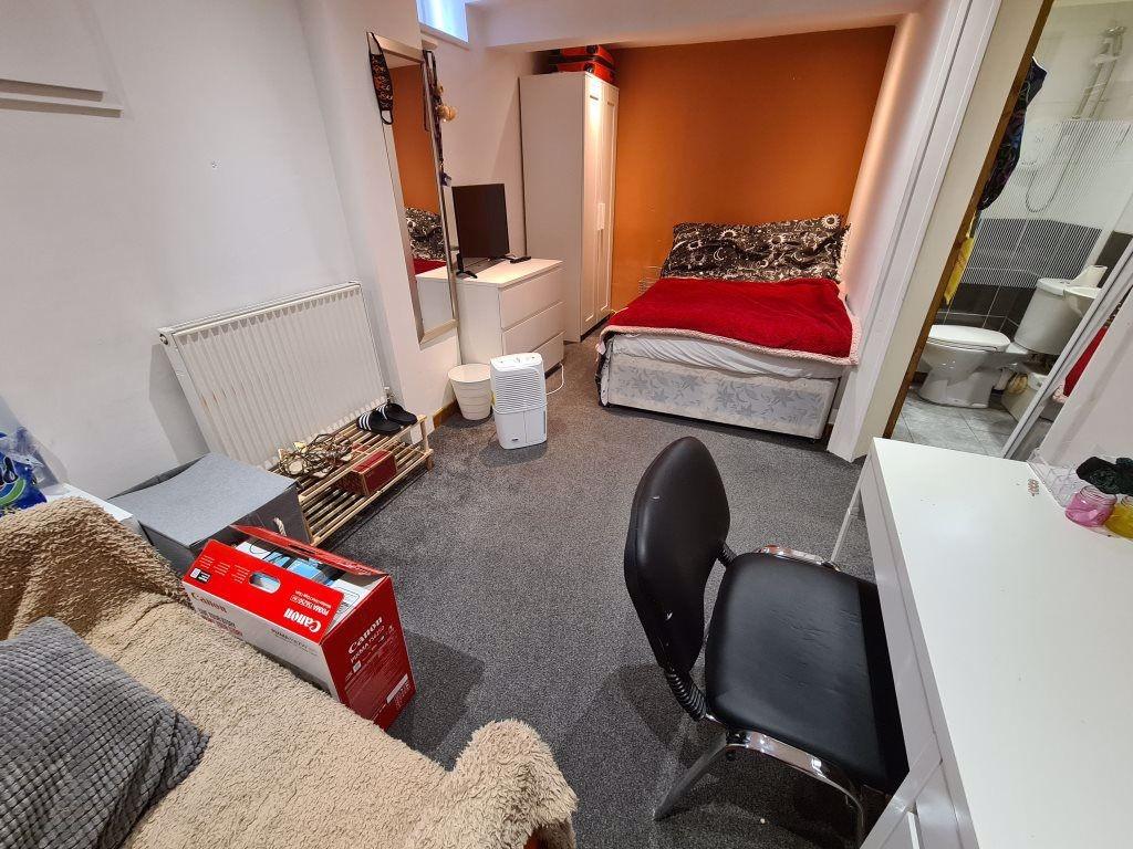 A cozy single bedroom featuring a comfortable b...