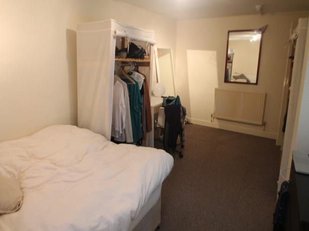 Neat, simply furnished double bedroom with a co...