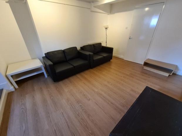 Bright, uncluttered living room with wood-effec...