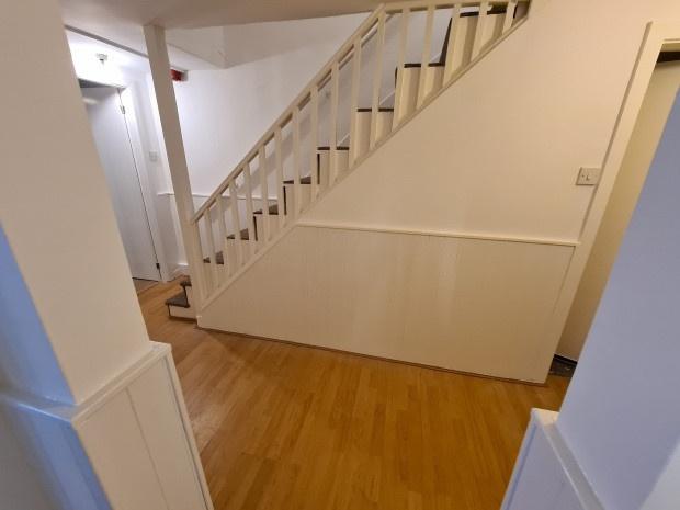 Bright, clean hallway with wooden flooring and ...