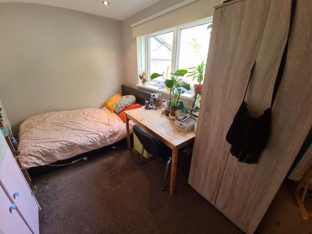 A cozy single bedroom featuring a comfortable b...