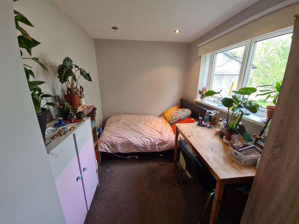 A cozy single bedroom featuring a comfortable b...