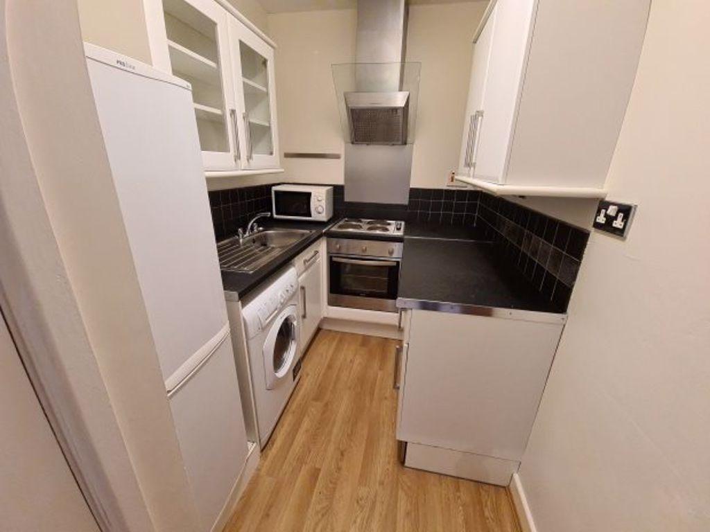 A compact, modern kitchen featuring integrated ...