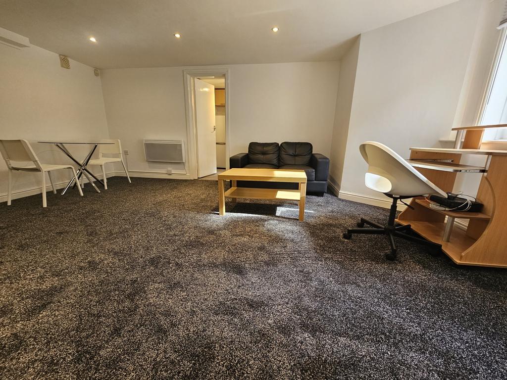 A spacious, well-lit living room featuring a co...