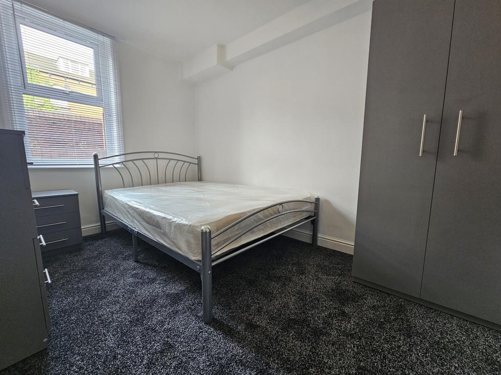Bright and tidy bedroom featuring a metal-frame...