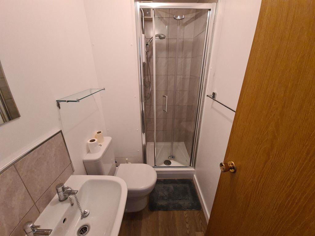 A modern bathroom featuring a compact shower cu...