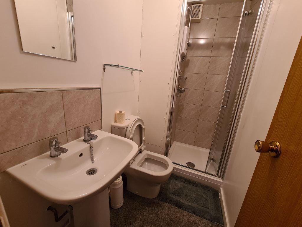 A well-maintained bathroom featuring a white ce...
