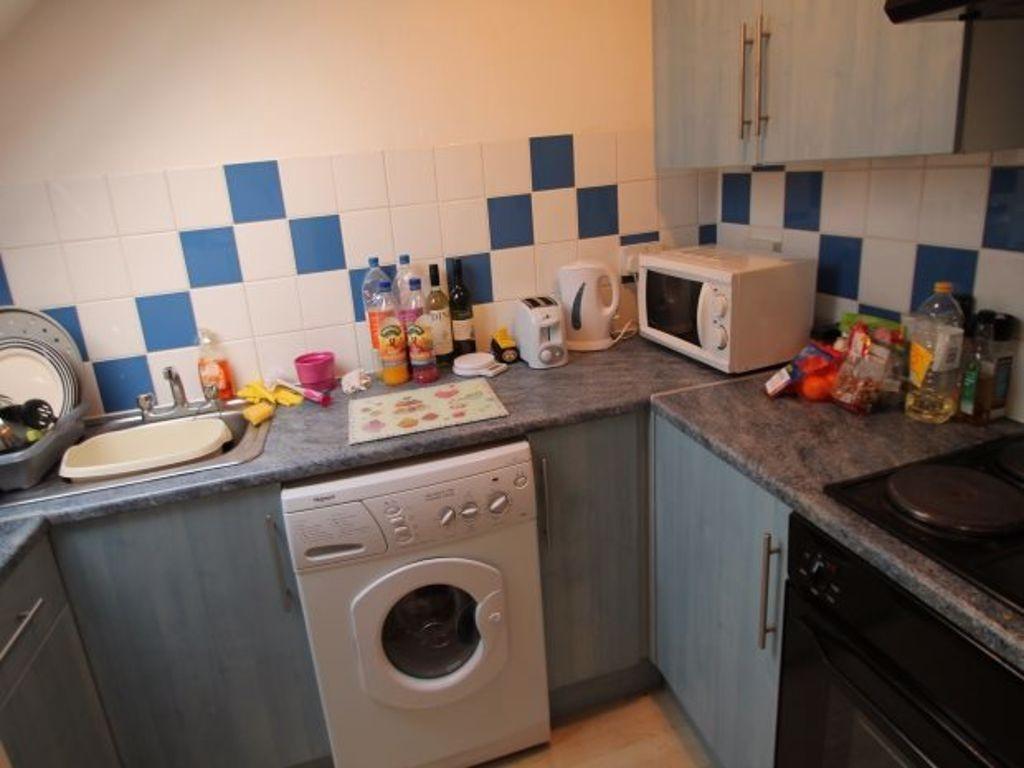 A compact kitchen featuring modern appliances i...